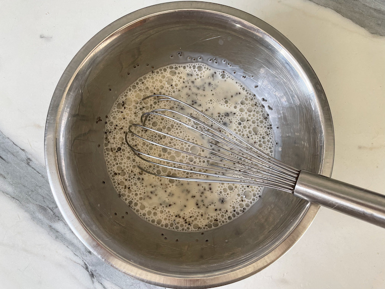 Chia seed pudding ingredients in a bowl with a whisk
