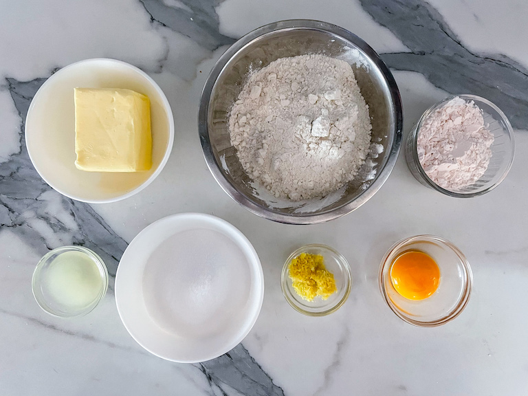 Lemon cookie ingredients arranged on a marble surface