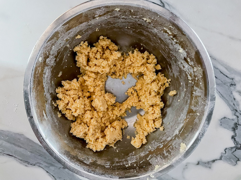 Clumpy cookie dough in a metal bowl