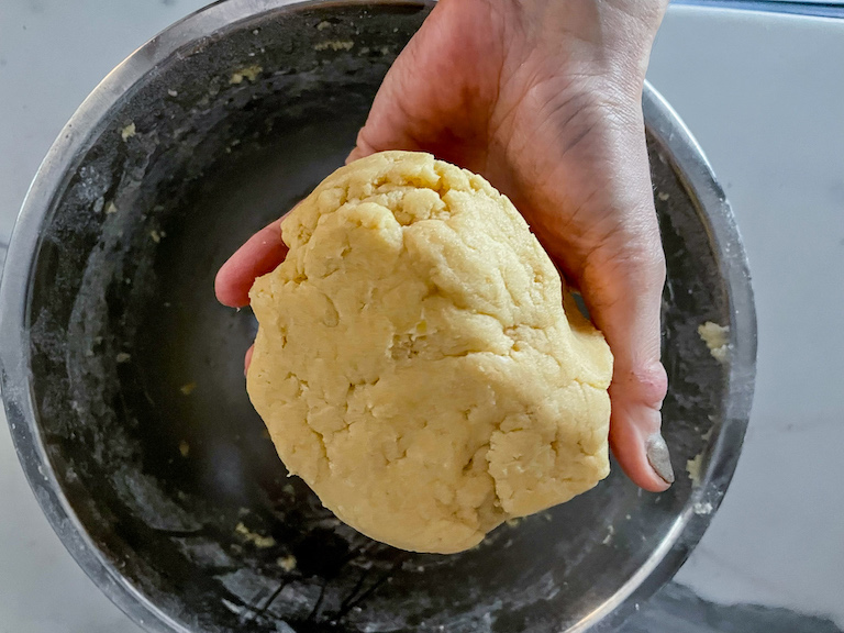 Hand holding a ball of cookie dough