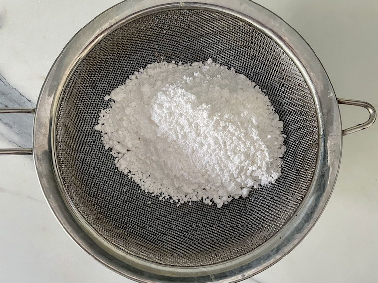Sifting confectioner's sugar through a mesh strainer