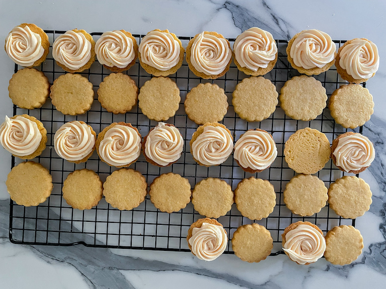 Cookies piped with lemon buttercream filling, arranged on a wire rack