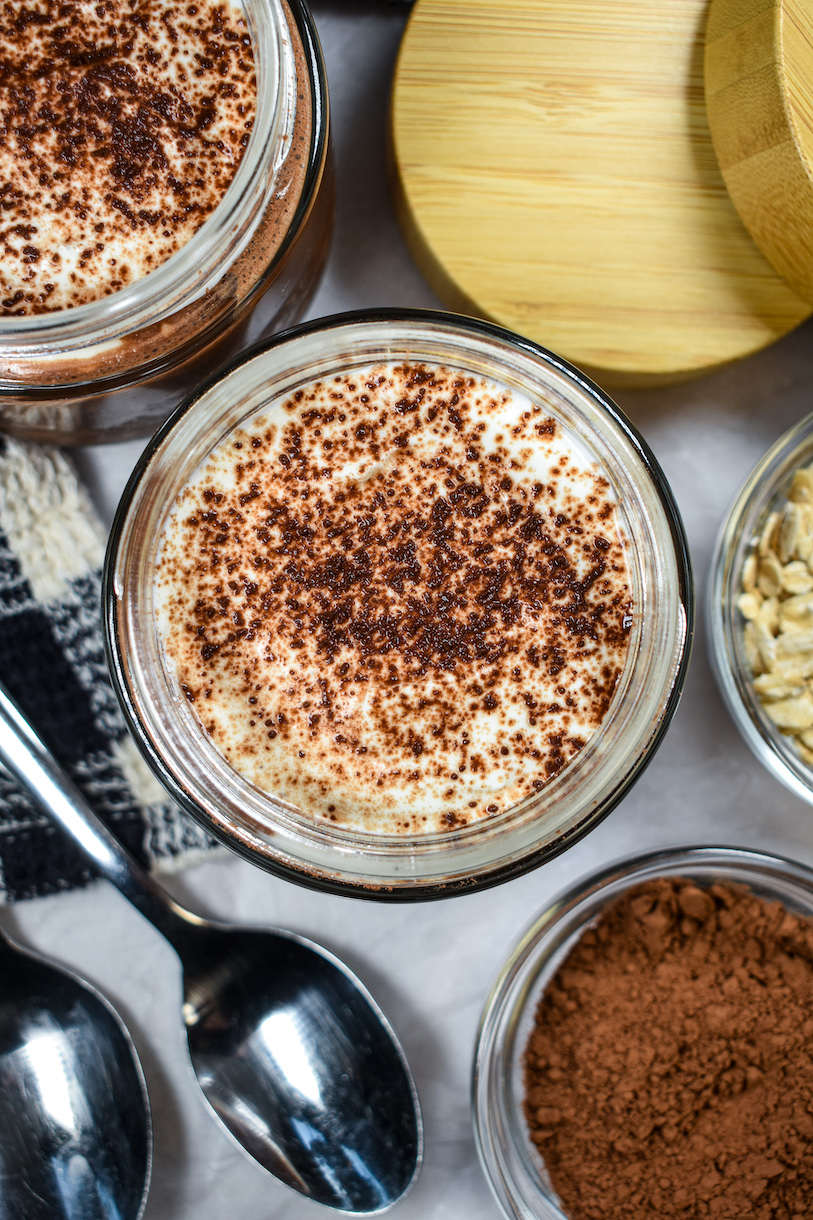 A jar of overnight oats dusted with cocoa powder