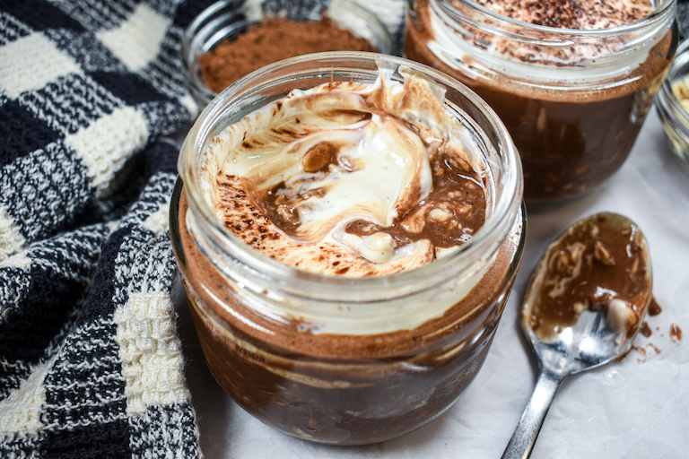 A half eaten jar of overnight oats with a spoon