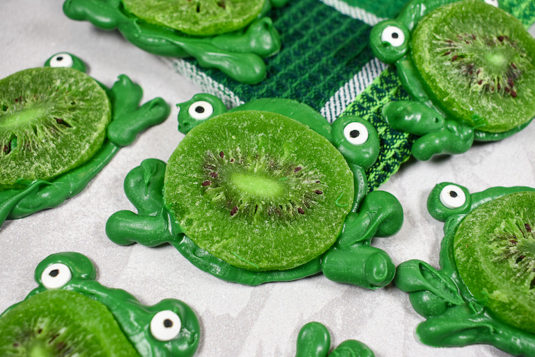 Green chocolate kiwi frogs arranged on a white surface