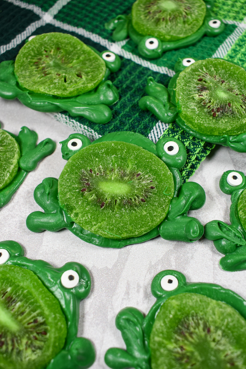 Chocolate frogs on a white surface with a plaid green towel