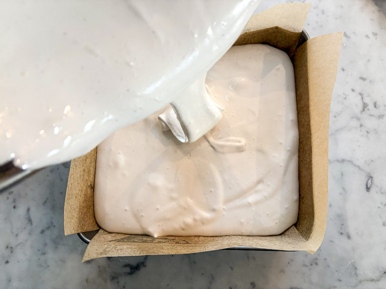 Pouring marshmallow into a parchment lined tin