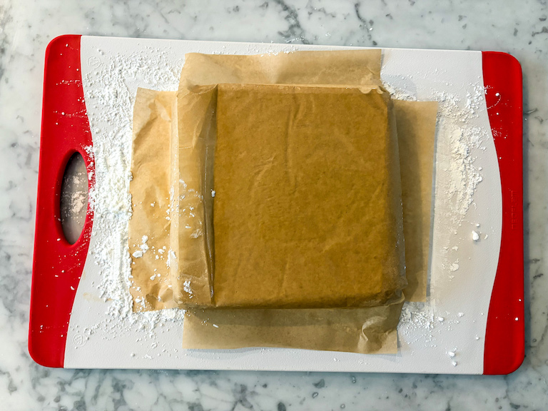 Parchment lined slab of marshmallow, upside down on a cutting board