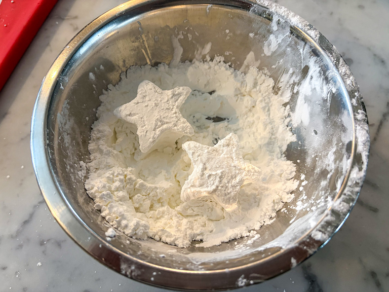 Tossing marshmallow stars in a bowl of cornstarch