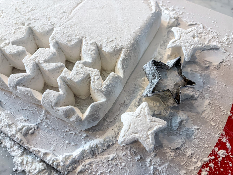 A metal cutter cutting star shaped marshmallows