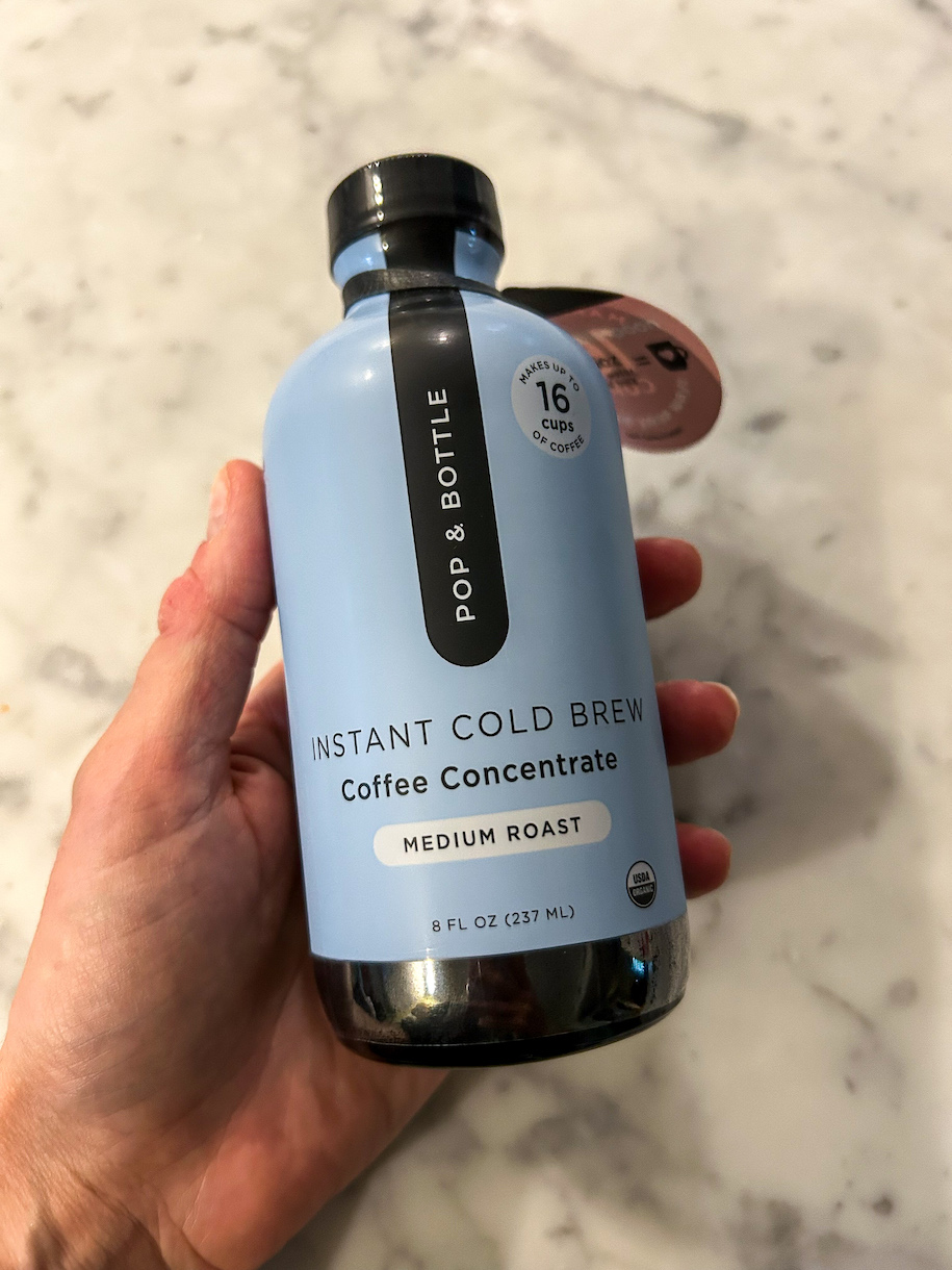 Hand holding a bottle of coffee concentrate
