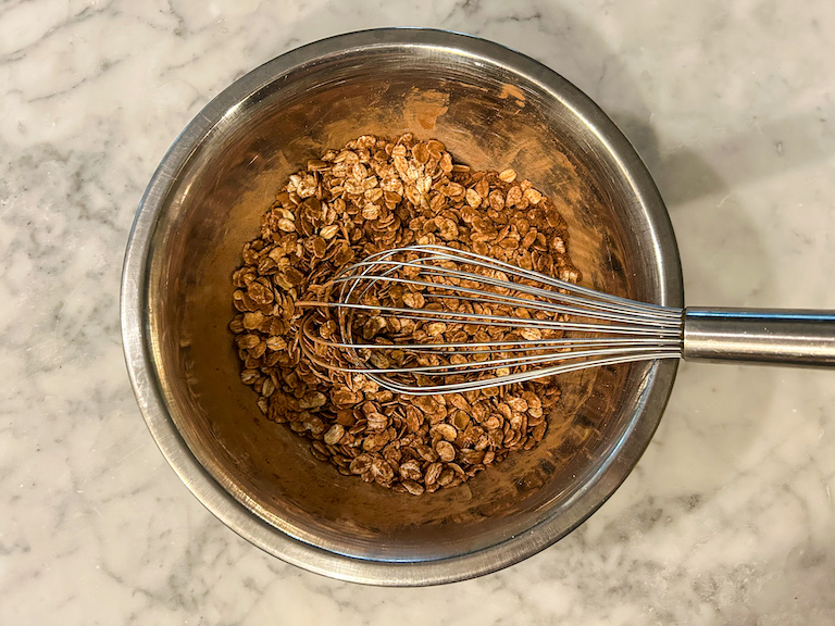 Oats and cocoa powder in a bowl with a whisk