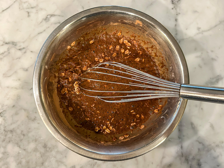 Tiramisu overnight oat ingredients in a bowl with a whisk