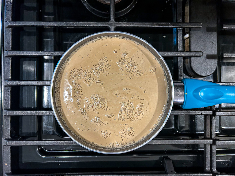 Coffee ice cream base cooking in a small pan on the stovetop