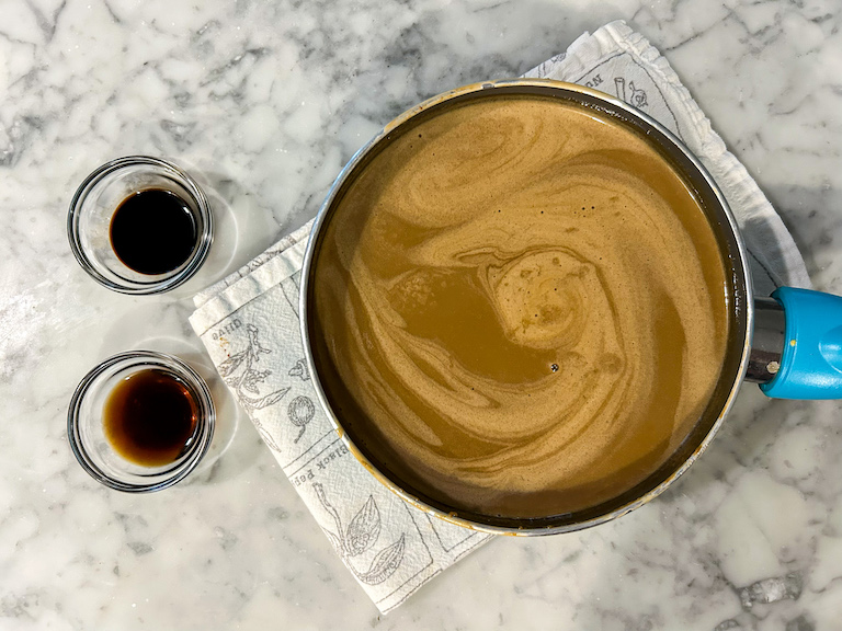 Cold brew ice cream base in a pan next to dishes of coffee extract and coffee brandy