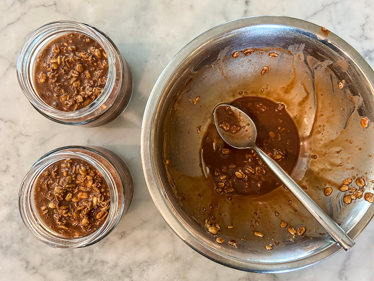 A bowl and two jars of overnight oats with a spoon
