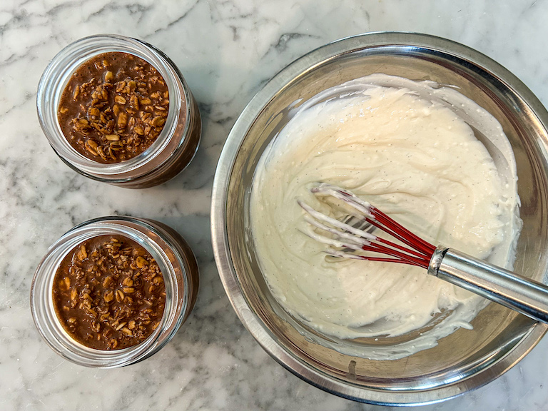 A bowl of cream topping and two jars of overnight oats
