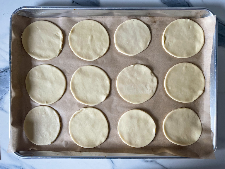 Discs of shortcrust pastry on a parchment lined tray
