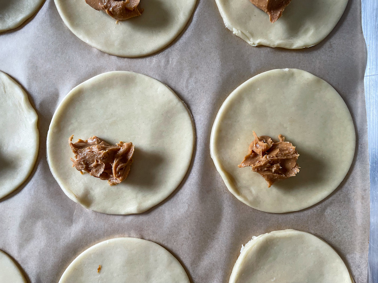 Spoonfuls of peanut butter on top of discs of shortcrust pastry