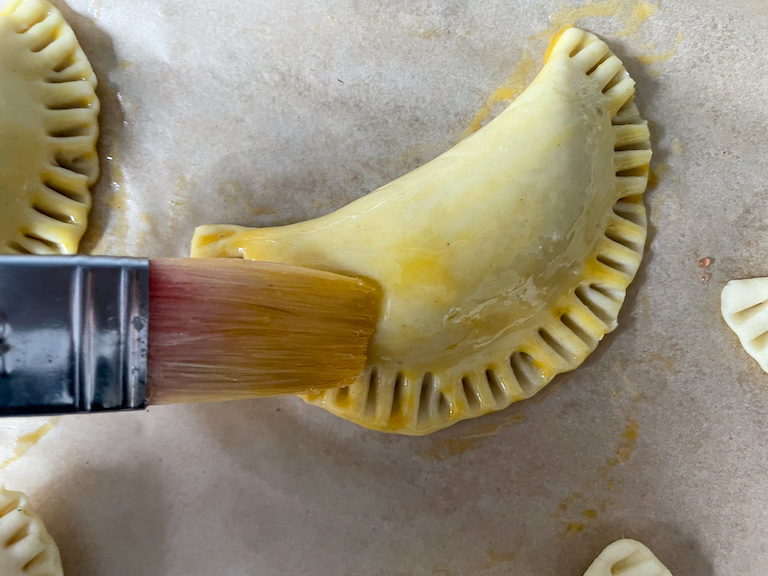 Pastry brush egg-washing a hand pie