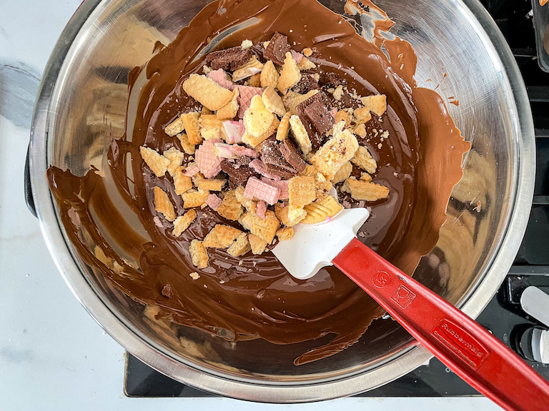 Stirring chopped biscuits into melted chocolate