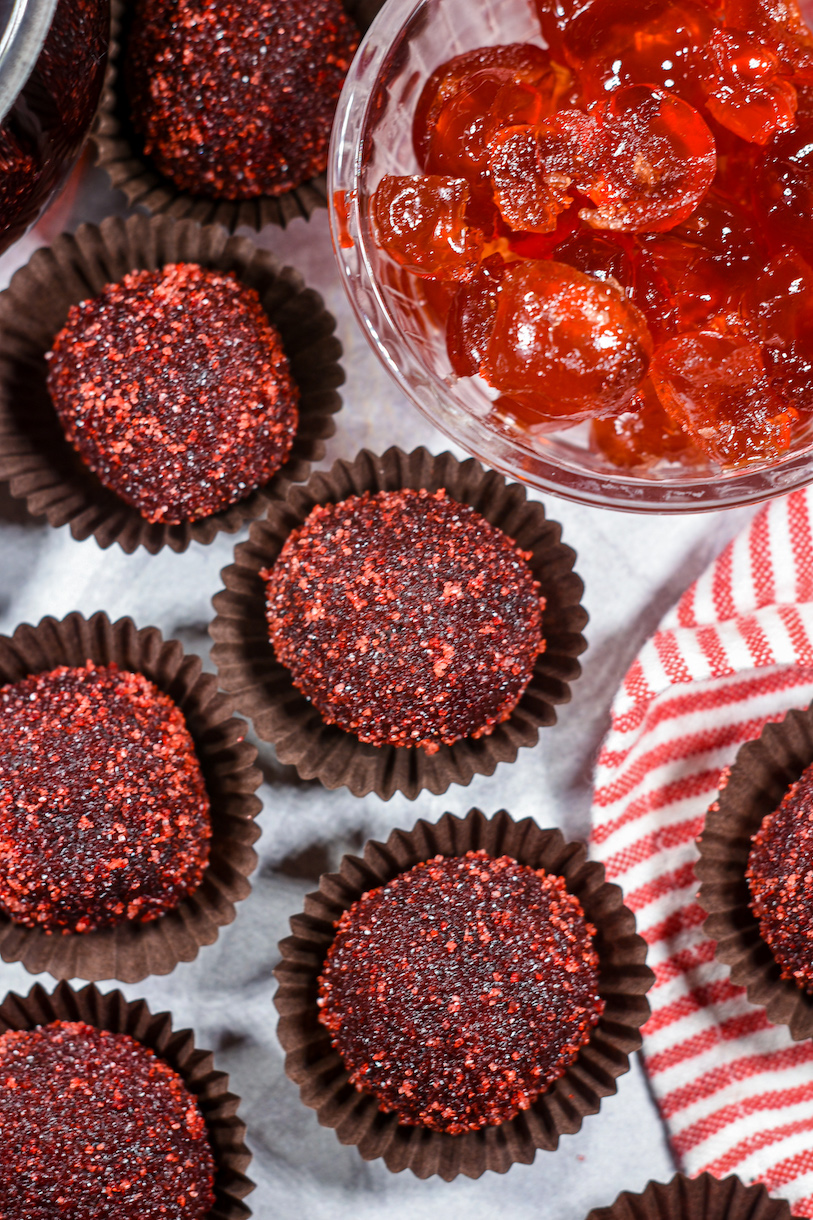 cherry cola truffles and dish of cherries on a white surface
