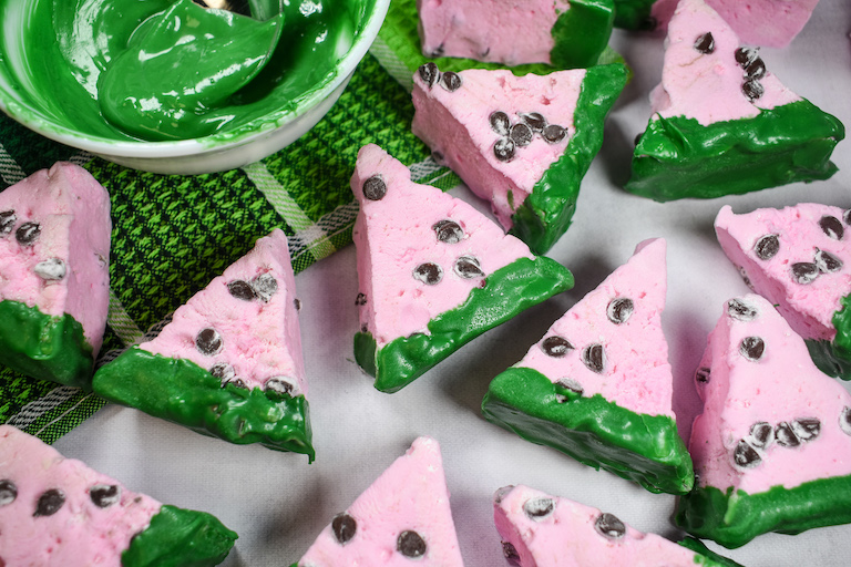 Watermelon marshmallows and a dish of green chocolate on a green tea towel