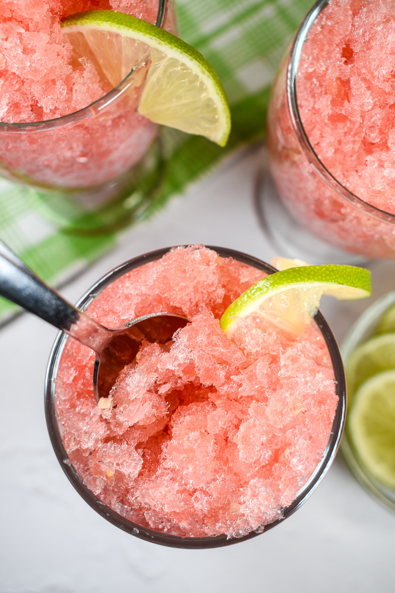 Looking down at a dish of watermelon granita garnished with sliced lime