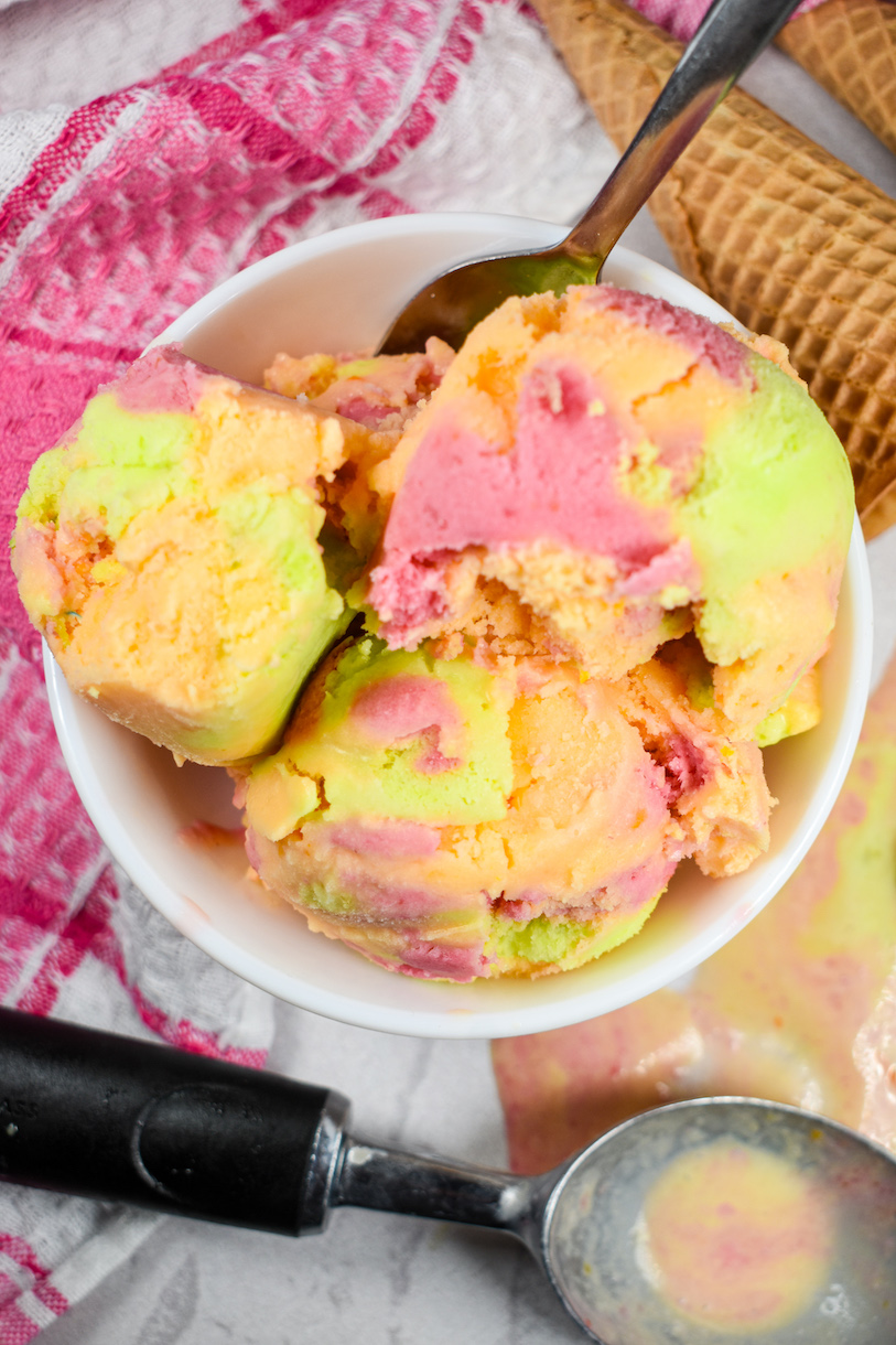 A bowl filled with scoops of rainbow sherbet