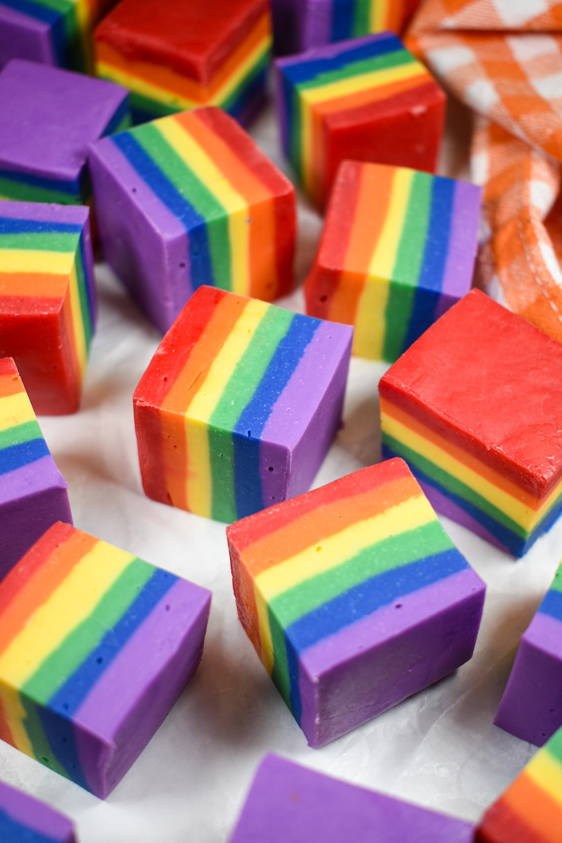 Cubes of rainbow fudge on a white surface