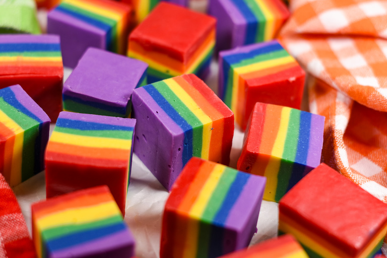 Slices of rainbow fudge arranged on a white surface