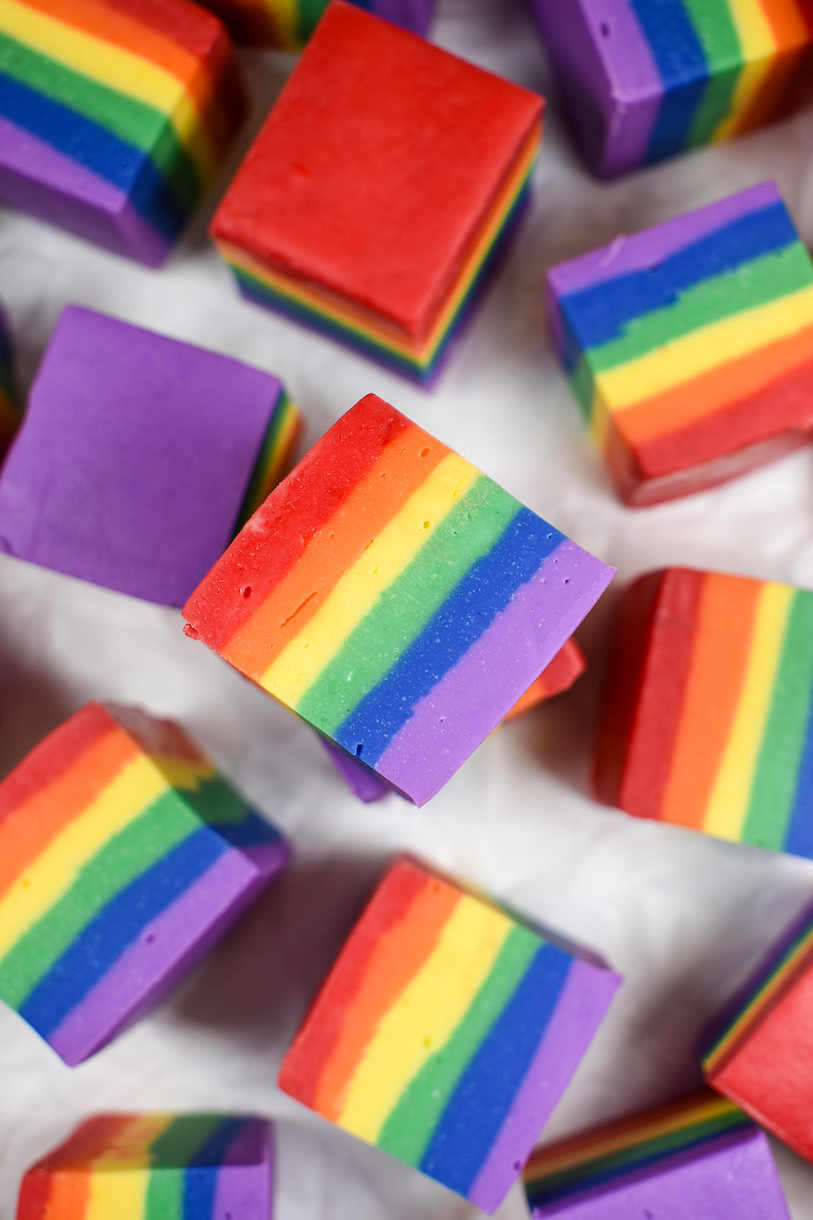 Cubes of rainbow fudge on a white surface