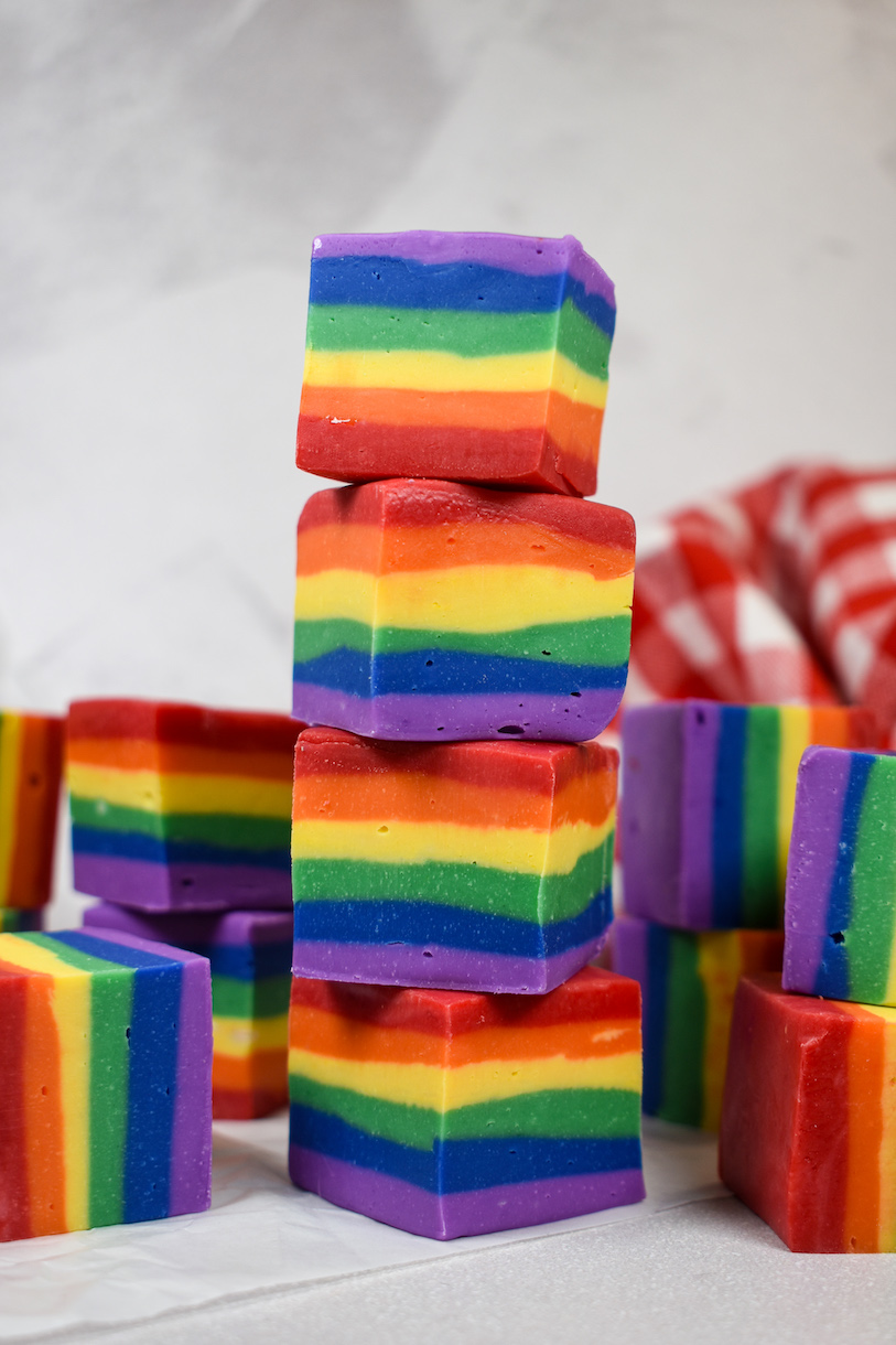 A stack of four pieces of striped rainbow fudge 