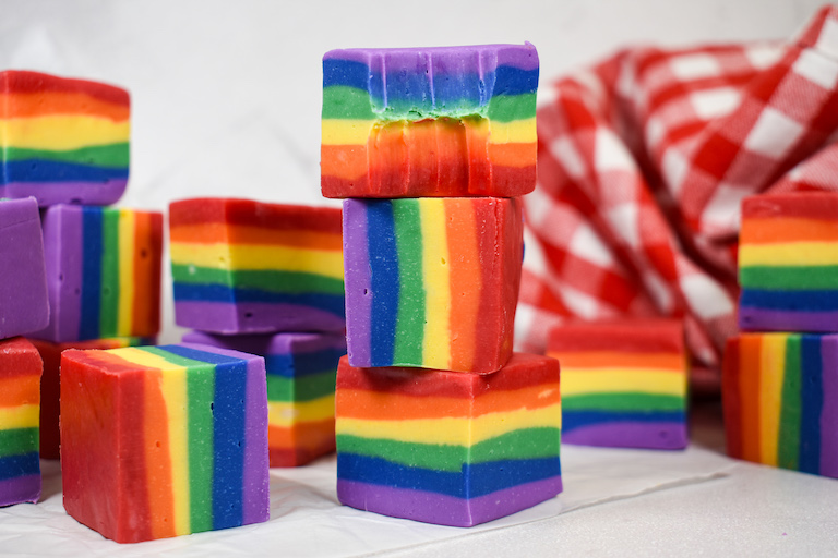 A stack of rainbow fudge on a white surface