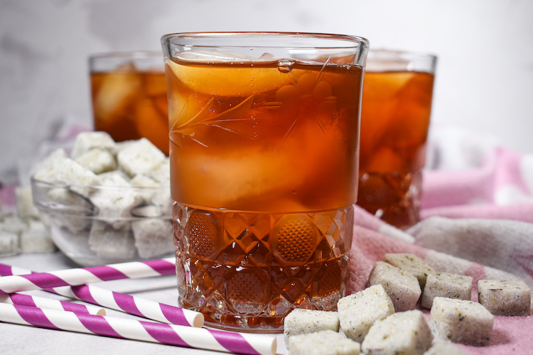 Glasses of lavender tea, sugar cubes, and striped purple straws