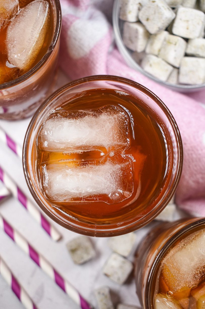 Looking down at a glass of iced tea with two ice cubes floating on top