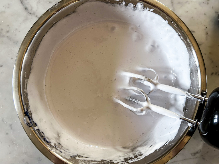 Marshmallow fluff in a bowl with a hand mixer