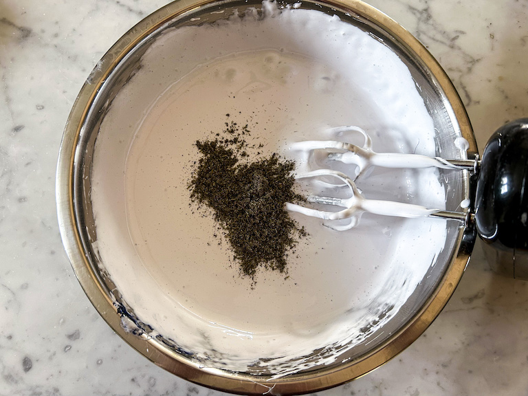 Adding ground dried lavender to a bowl of lavender marshmallow fluff