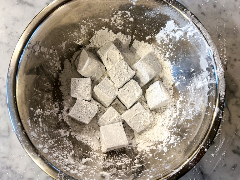 Marshmallows in a bowl of powdery coating