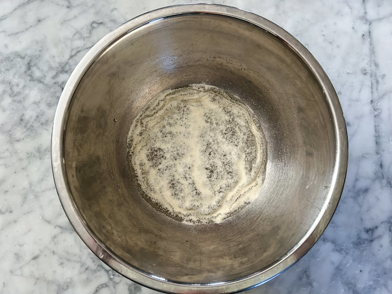 Gelatin sprinkled over water in a metal bowl