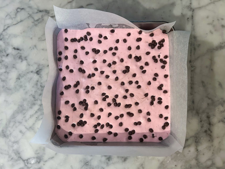 A pan of pink marshmallow dotted with miniature chocolate chips