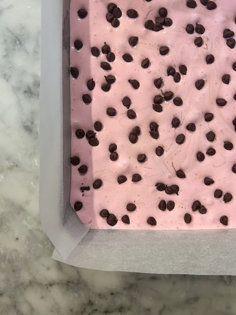 A pan of pink watermelon marshmallows with mini chocolate chips on top
