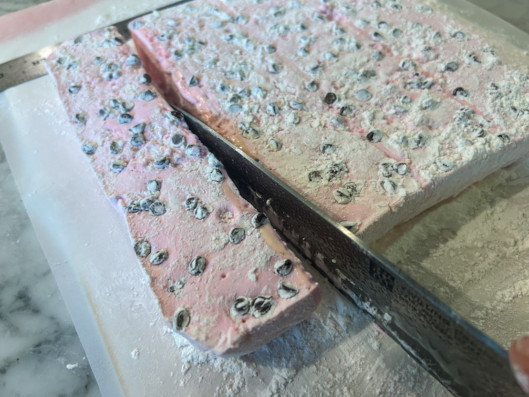 Knife slicing a slab of homemade marshmallows
