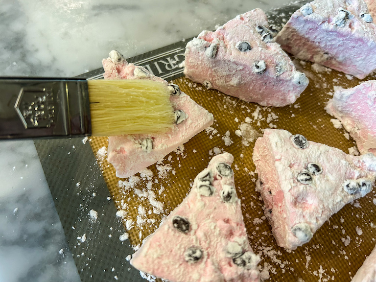 Pastry brush brushing cornflour away from watermelon marshmallows