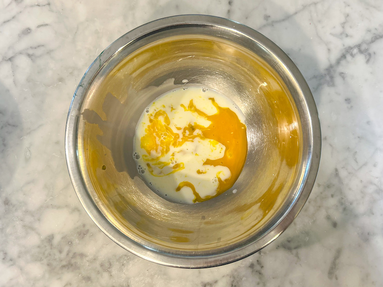 Eggs and cream in a metal bowl