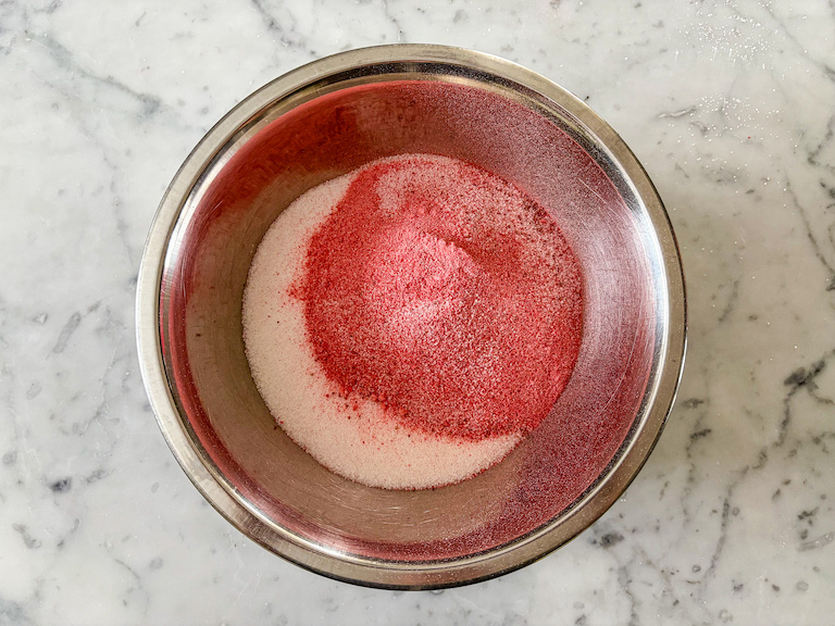 Powdered strawberries with granulated sugar in a metal bowl