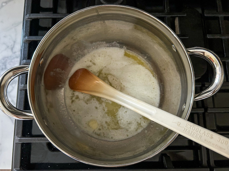 Melted butter in a stock pot with a spoon