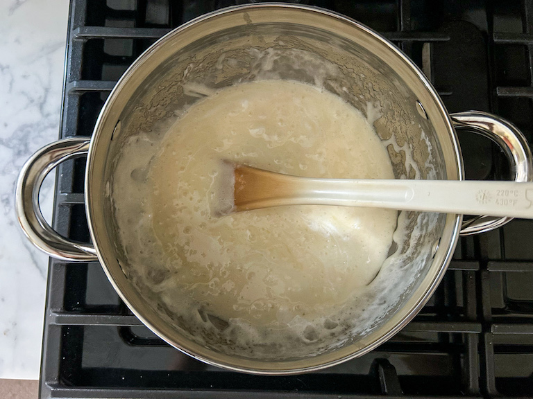 Melted marshmallow in a stock pot with a spoon