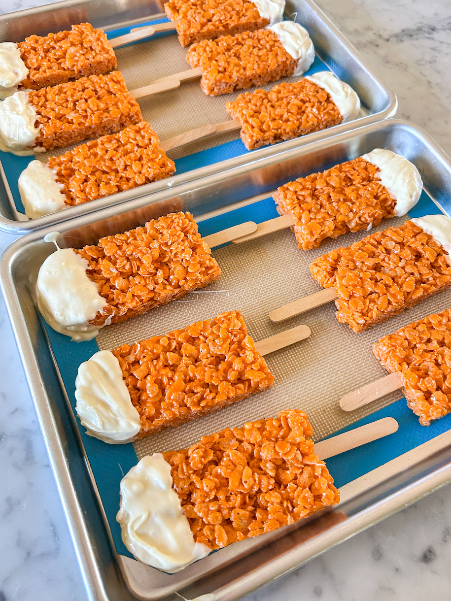 Krispie treat popsicles arranged on two small trays