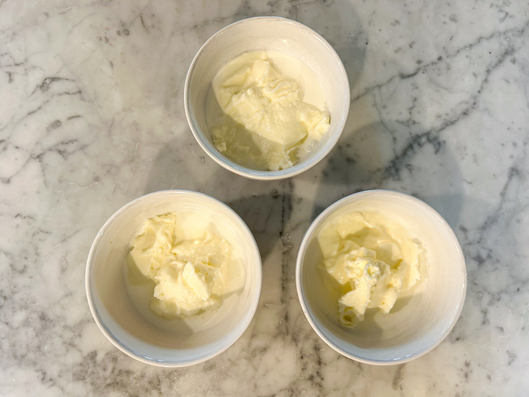 Ice cream base scooped into three small white bowls